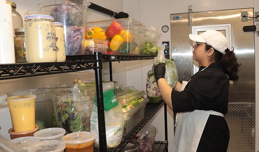 Culinary Arts student looking for vegetables in the fridge.
