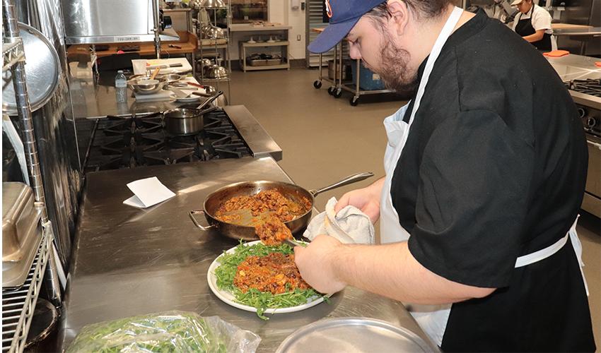Culinary Arts student spends time plating his culinary dish.