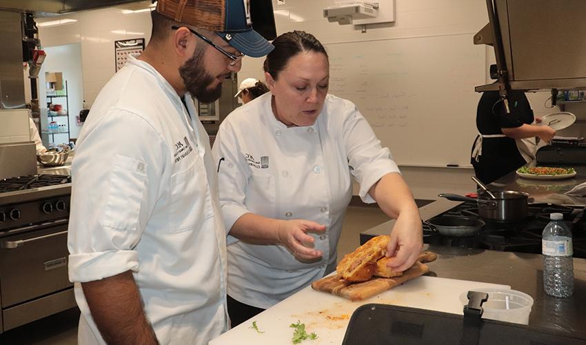 Chef Laura showing her student some plating techniques.
